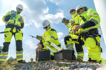 Team of engineers in uniform with helmet safety using drone for inspection and maintenance of wind turbine blade at wind farms or construction site to generate electrical energy, Renewable energy.