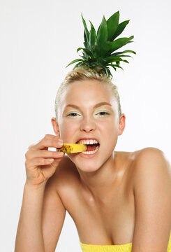 Portrait of Woman Biting Pineapple