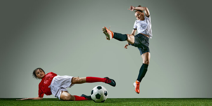 Rainy weather training session. Powerful action of two female soccer players in middle of intense play, competing for the victory. Concept of sport, action, competition, game. Copy space