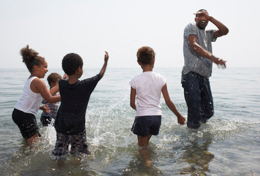 Children Splashing Man in Lake