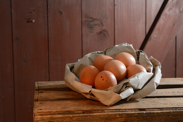 Organic brown eggs in paper on wooden table