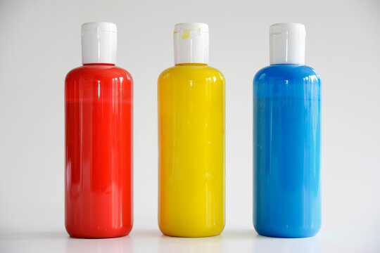 Red, Yellow, Blue bottles on gray background