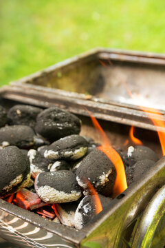 Burning coal briquets on grill in garden