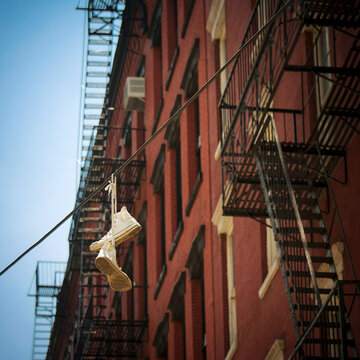 USA, New York City, SoHo, Trainers hanging on electric cable