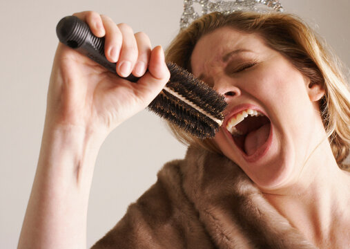 Woman Dressed Up, Singing Into Hair Brush