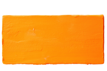 Close-up of thick orange paint block with textured surface isolated on white background