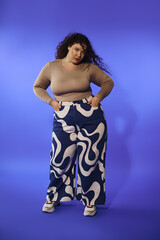 A confident plus size woman showcases her fashion sense in vibrant patterned pants, exuding joy.