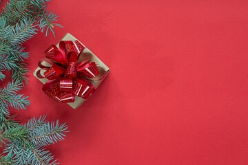 Festive red gift box with fir branches on a red background. Christmas and New Year concept, holidays, copy space.