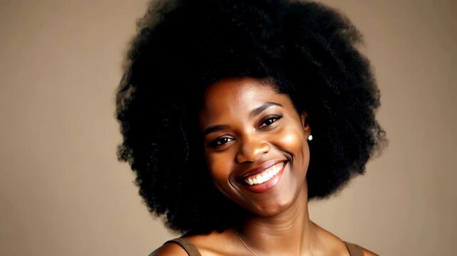 Close-up portrait of a smiling Black woman with a large afro hairstyle against a brown background