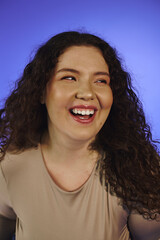 A happy plus size woman shines with her stunning curls and radiant joy.