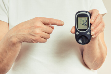 Senior woman and glucometer with result of sugar level. Diabetes in old age