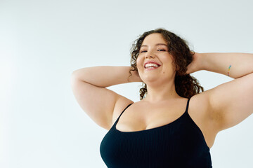 A vibrant plus size woman with curly hair radiates happiness, embracing her confident spirit.