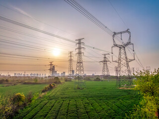 Aerial shot of high voltage electricity tower and natural scenery at sunset