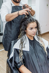 Beautiful young Latin, Peruvian, Hispanic woman with her stylist, they are painting her hair blonde, the entire process is recorded until the end