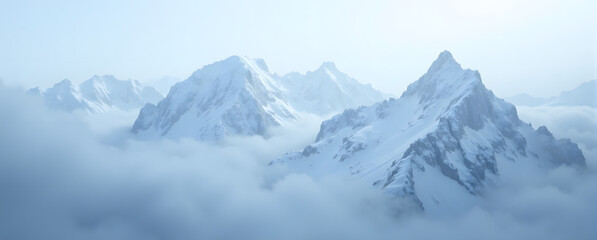 Obraz premium Serene snow-capped mountain peaks emerging through misty clouds