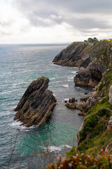 Spectacular natural lanscape in north of Spain, Asturias. Green coastline of Spain. High cliff. Turquoise water.  Waves breaking on the rock. Famous travel destination. 