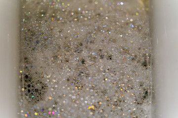 Top view of toilet with foam and bubbles with rainbow colors reflections and bokeh lights. Photo taken October 31st, 2024, Zurich, Switzerland.