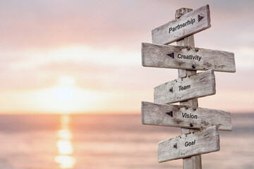 partnership creativity team vision goal text quote written on wooden sign outdoors by the sea
