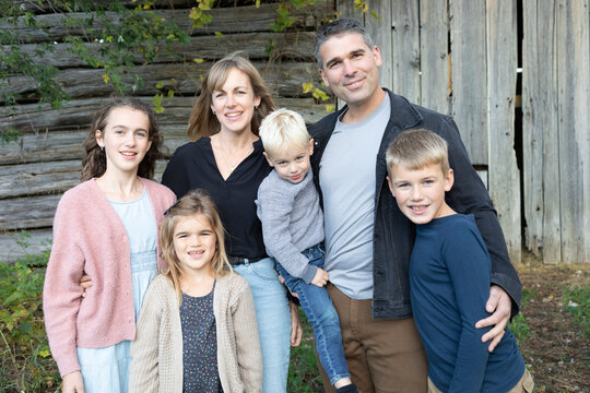 Portrait of a family standing in front of a wooden building in Beckwith Township at Carleton Place in the Ottawa Valley; Ontario, Canada