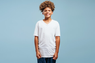 Smiling, happy handsome African American boy wearing stylish white t shirt, mockup looking at camera