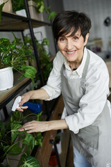 A mature gardener tends to her beloved indoor plants with care.
