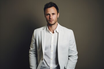 Fototapeta premium Portrait of a tender man in his 30s wearing a chic cardigan while standing against light wood minimalistic setup