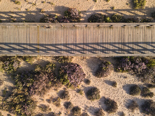 Top-down view of the wooden boardwalk for walking across sand dunes in Algarve