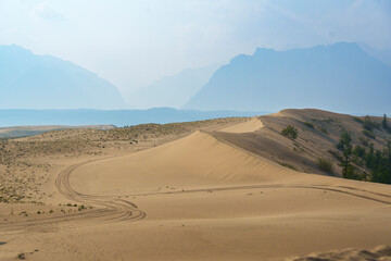 Golden desert dunes illuminated by sunbeams under a dramatic sky