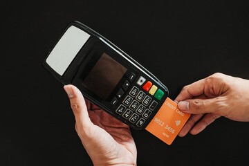 Hand making transaction using credit card on EDC machine. Cashless, Cashless, modern wireless payment, financial and business concept.