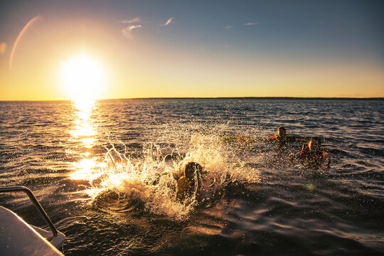 Swimming and having fun at the lake during a family outing at sunset on Lac Ste. Anne, Alberta; Alberta Beach, Alberta, Canada