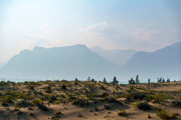 View of a sandy plateau surrounded by forest and mountains