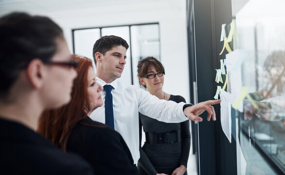 Colleagues, group and reading of sticky notes, glass and collaboration for brainstorming and ideas. Communication, teamwork and corporate people with information, underwriter and insurance company