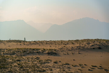 View of a sandy plateau surrounded by forest and mountains