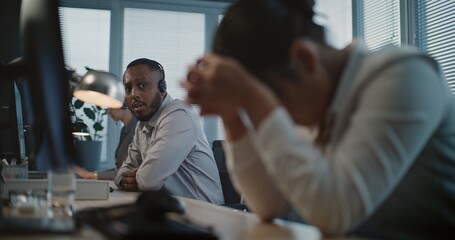 Call center office: Close up of tired Asian female helpdesk specialist holding head, feeling...