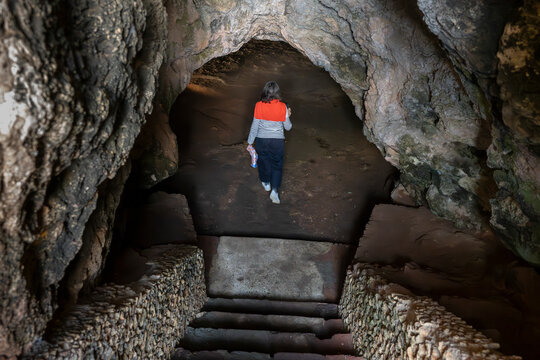 Woman enters the Cave of Lapa de Santa Margarida; Sao Lourenco, Setubal, Portugal