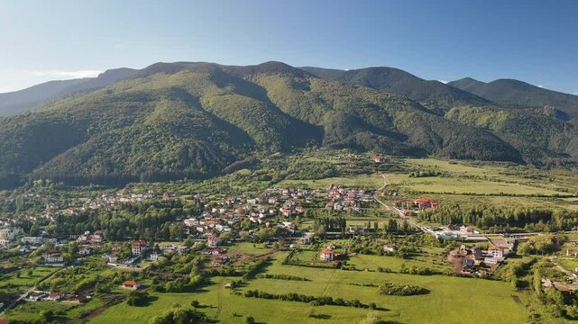 Drone pullback view of Sapareva Banya town with Rila Mountain in the background in Bulgaria