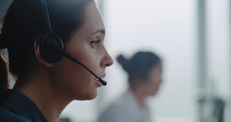 Close up of Caucasian female hotline operator in headset having conversation on call with customer,...