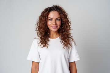 Fototapeta premium Young woman posing confidently in casual attire against a neutral backdrop