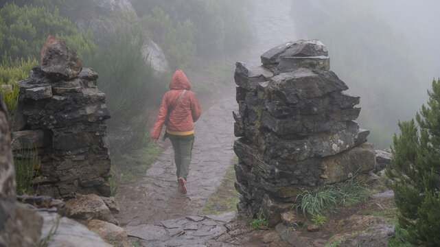 Female tourist on the trail in the fog at the highest peak, Pico Ruivo, on the island of Madeira, Portugal; Ilha, Madeira, Portugal