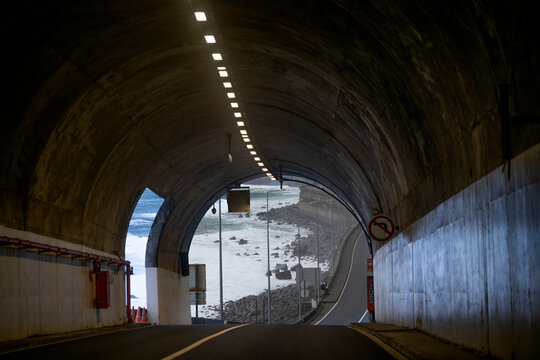 Fototapeta Scenic view through highway tunnel to the coastal shore of the Atlantic Ocean at Calheta  Calheta, Madeira, Portugal