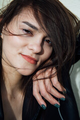 Portrait of a beautiful fashionable slender woman in a black leather jacket
