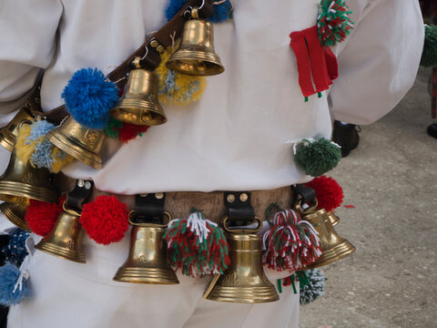 Small decorative brass bells and pom poms decorating a costume at the carnival of the Zanni in Italy; Umito and Pozza, Acquasanta, Marche region, Italy