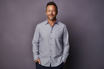 Obraz premium Portrait of a glad man in his 40s showing off a lightweight base layer isolated in plain cyclorama studio wall