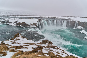 Godafoss waterfall cascading during snowfall in iceland