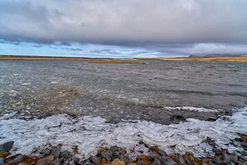 Ice forming on the rocky shore of a lake in iceland