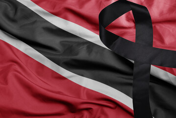 waving national flag of trinidad and tobago with black mourning ribbon . tragedy concept
