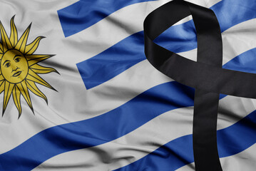 waving national flag of uruguay with black mourning ribbon . tragedy concept