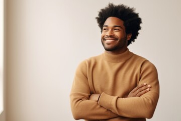 Fototapeta premium Portrait of a blissful afro-american man in his 30s dressed in a warm wool sweater in front of crisp minimalistic living room