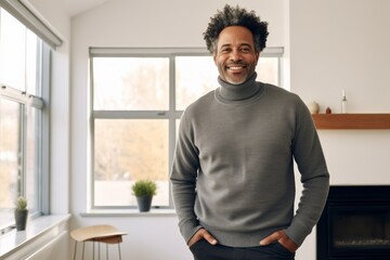 Fototapeta premium Portrait of a happy afro-american man in his 40s wearing a thermal fleece pullover isolated on crisp minimalistic living room