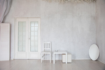 mirror chair and table in the interior of an empty white room